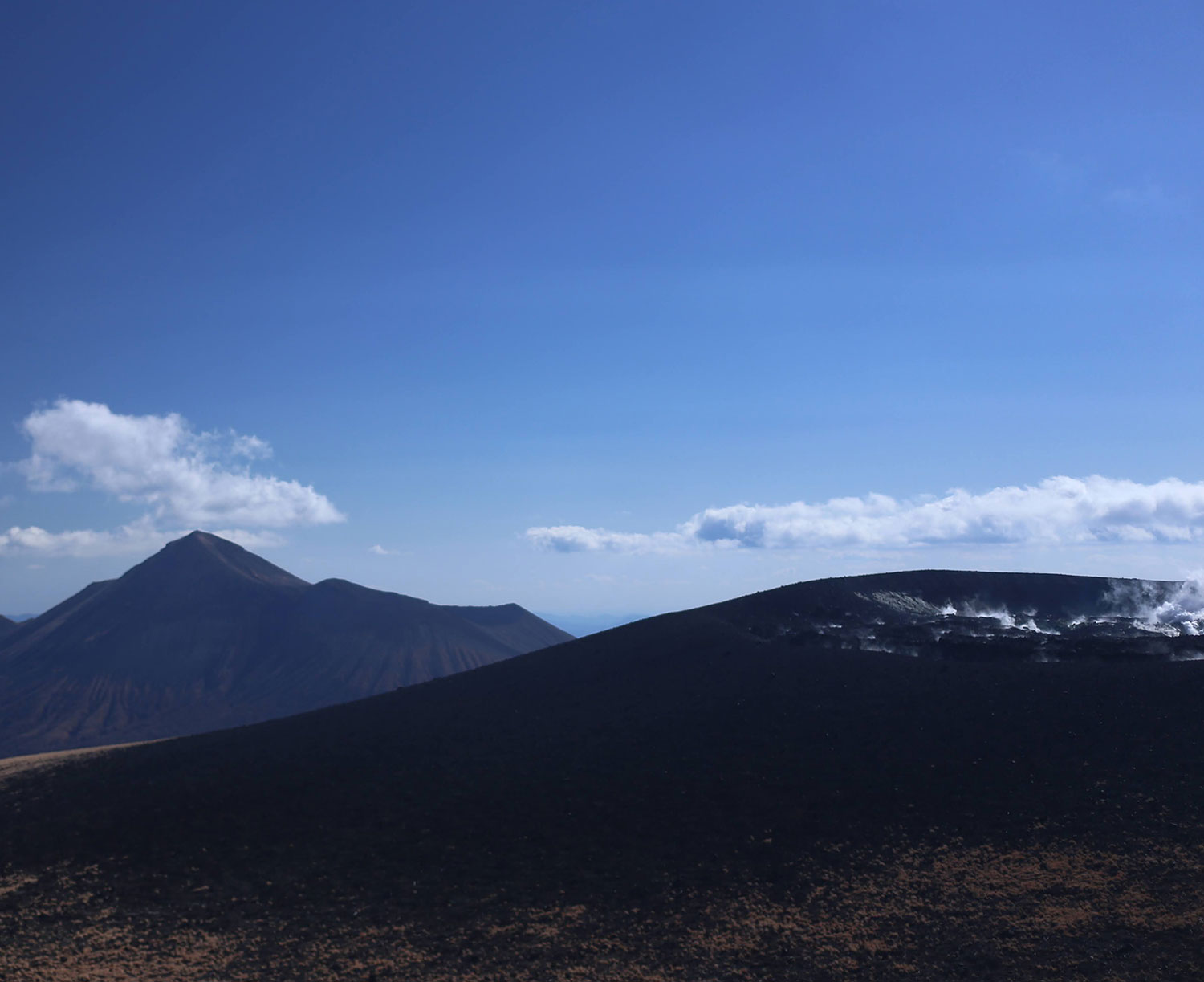 噴気を上げる新燃岳(手前)と高千穂峰(奥)